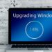 A laptop screen showing 'Upgrading Windows' at 14% on a desk with a white brick wall backdrop illustrating Unlock the Secrets: SEO Best Practices for Effective Content Updates.