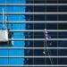 Essential WordPress maintenance tips to keep your site thriving 9 High-rise window cleaners suspended on ropes cleaning a reflective blue glass façade, illustrating Essential WordPress maintenance tips to keep your site thriving.