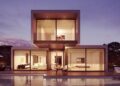 Contemporary two-story glass house at twilight with pool reflections, illustrating stability to Unlock Your Website’s Potential with Regular Maintenance