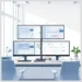Modern office desk with four monitors showing analytics dashboards for a Guide to Monitoring WordPress User Behavior Across Multiple Sites.