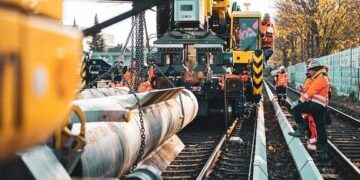 Avoid These 3 Website Maintenance Mistakes to Boost Performance 10 Construction crew in high-visibility gear installing a large pipeline along railway tracks, illustrating the need to Avoid These 3 Website Maintenance Mistakes to Boost Performance.