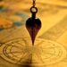 A vintage pendulum over a compass on an old map symbolizes Master the Art of Scheduling Website Backups for Ultimate Security.