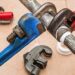 Close-up of pipe wrenches, tubing cutter, and thread tape illustrating Essential Website Maintenance Reporting Tools You Can’t Ignore