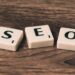 Three Scrabble-style tiles spelling SEO on a wooden surface illustrating Unlock Lightning-Fast Website Performance: 10 Must-Know Tips