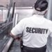 Uniformed security guard on an escalator with SECURITY printed on the shirt illustrating Neglecting Website Security Updates: The Risks You Can’t Afford