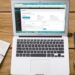 MacBook Air displaying a website admin dashboard on a wooden desk next to a smartphone, notebook, and coffee — Uncover the Best Tools for Website Uptime Monitoring Today!